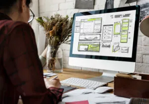 Website development layout sketch drawing on computer screen.