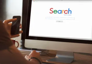 Person sat in front of computer screen with a search engine waiting.