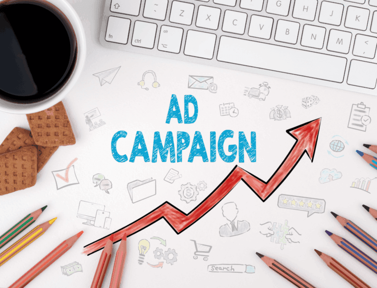 Sheet of paper next to a computer keyboard with ad campaign written in bold blue text and a red graph chart trending upwards.