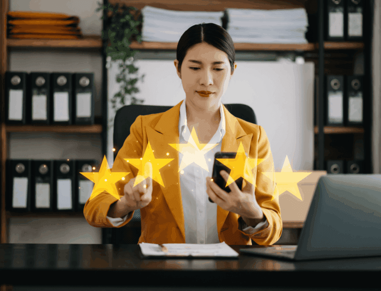 Woman sat at work desk with a rainbow of five golden stars visible.